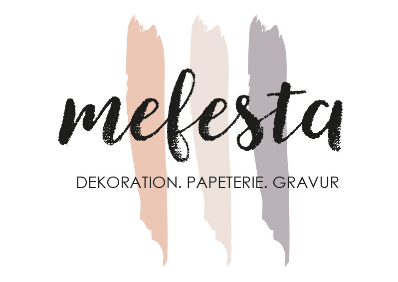 Logo mit dem handschriftlichen Schriftzug „mefesta“ in Schwarz vor drei vertikalen Pinselstrichen in Beige-, Grau- und Rosétönen; darunter steht in Großbuchstaben „DEKORATION. PAPETERIE. GRAVUR“.